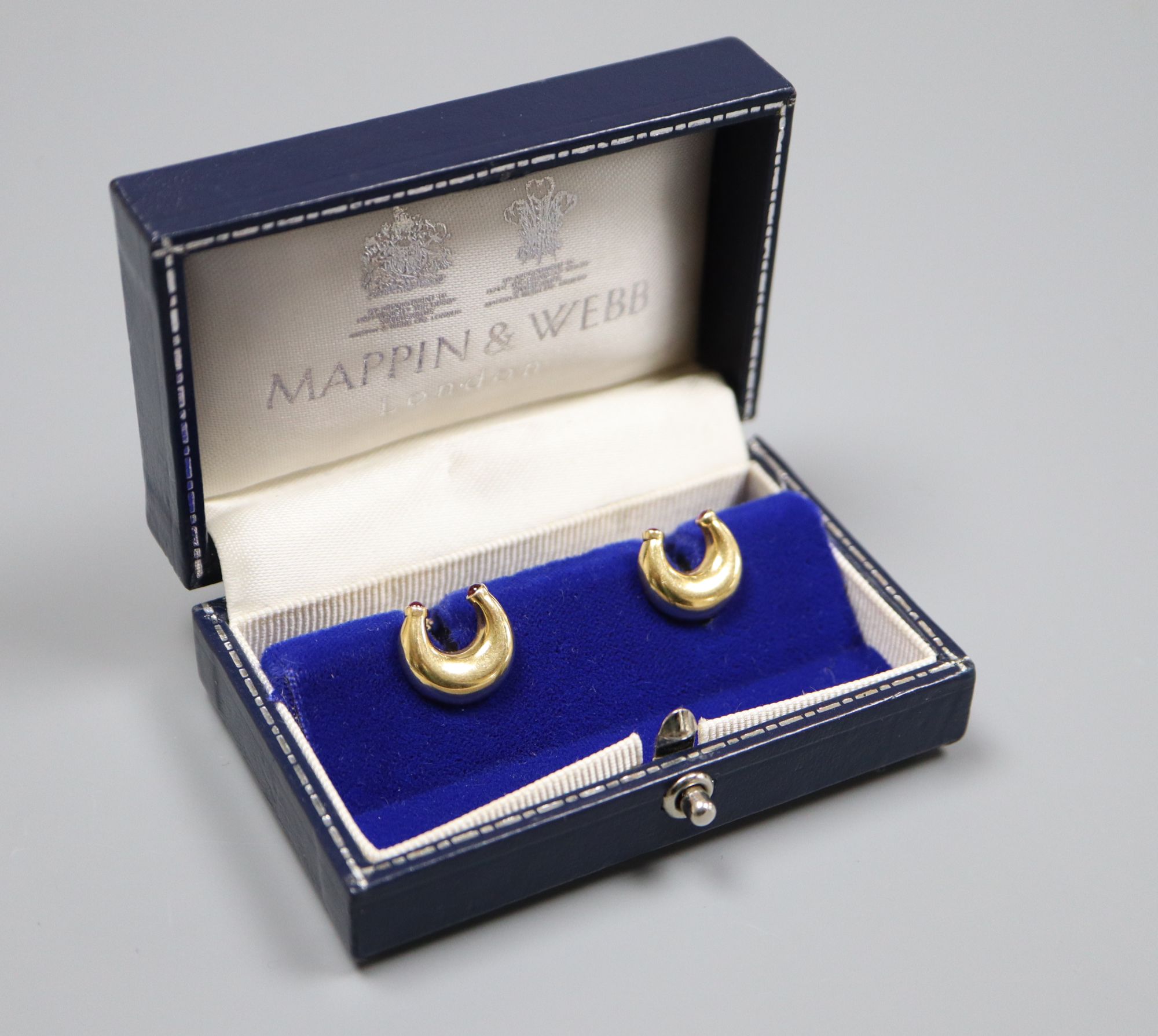 A pair of modern 18ct gold and ruby set horseshoe shaped cufflinks by Mappin & Webb